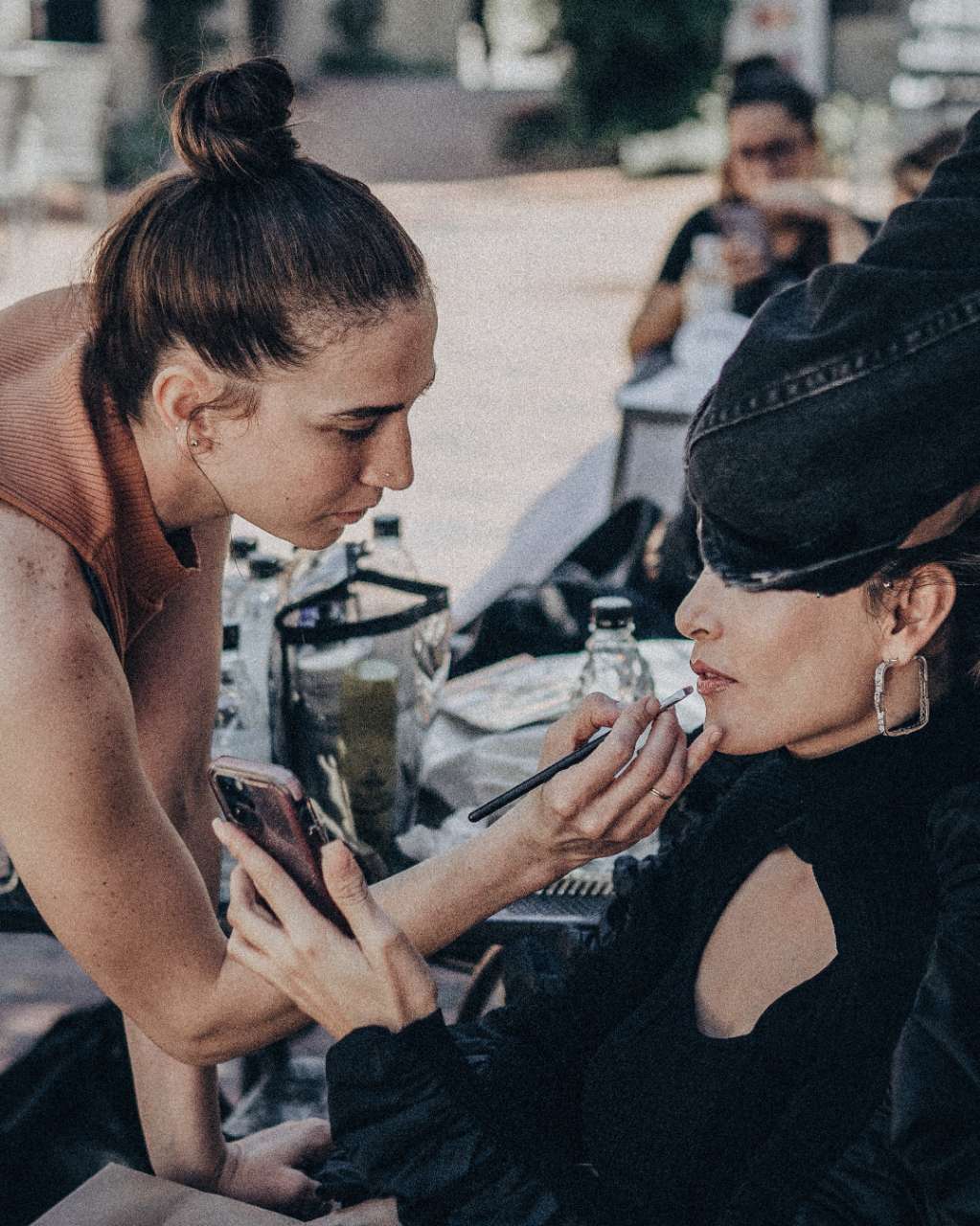 A woman having her makeup applied by a professional, capturing the essence of beauty enhancement and skillful artistry.